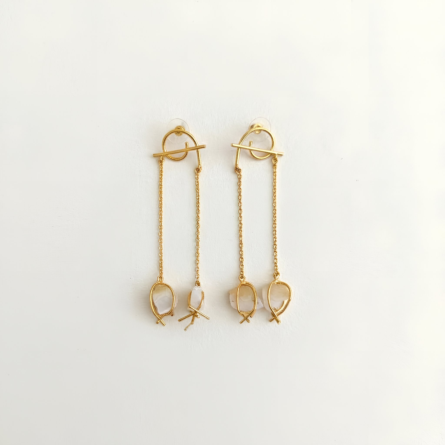 Front view of semi-precious white druzy stone dangler earrings with a minimal gold chain design