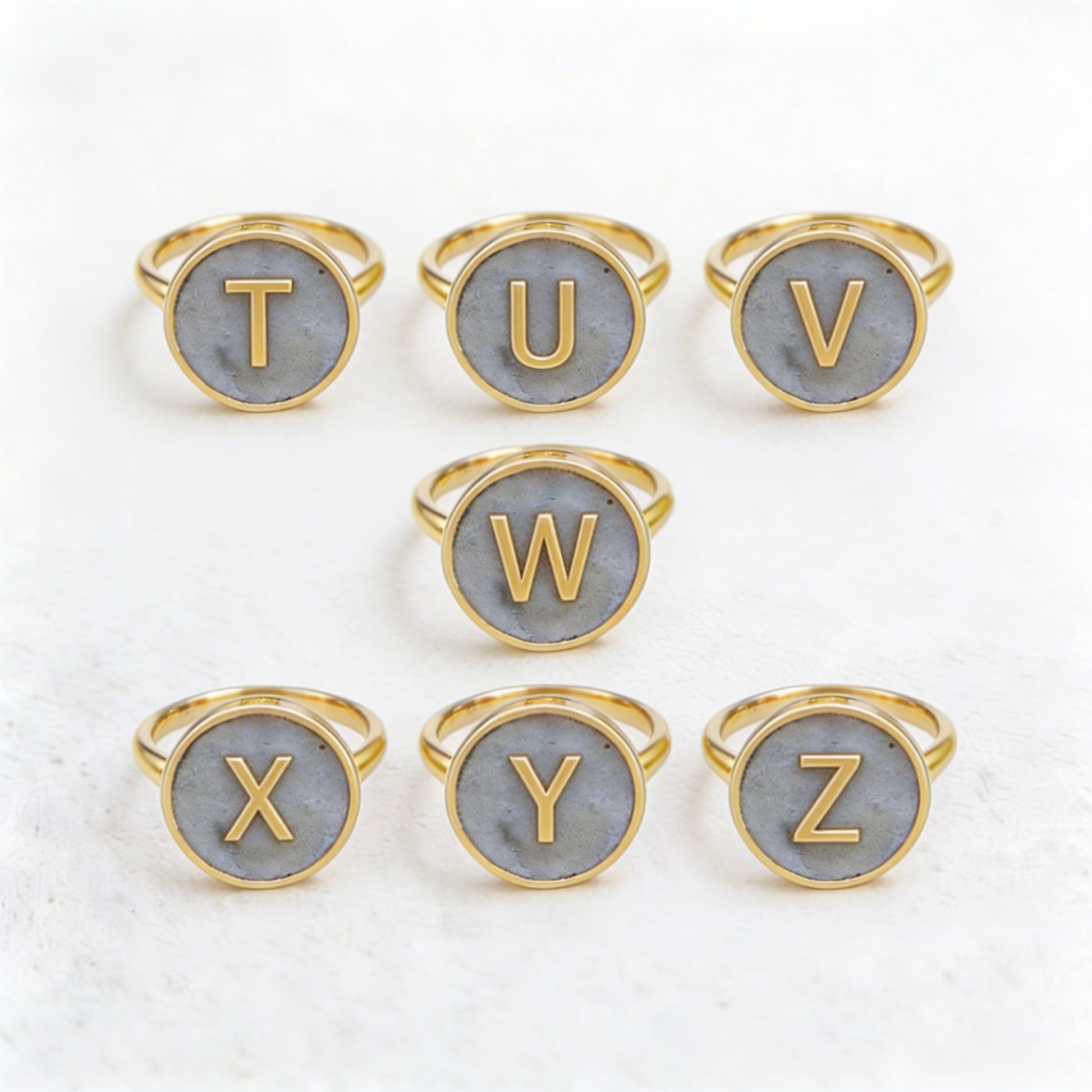 Set of gold letter rings with cement