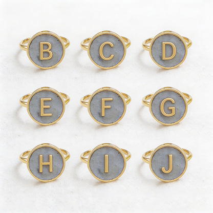 Set of gold and gray initial rings on a white background