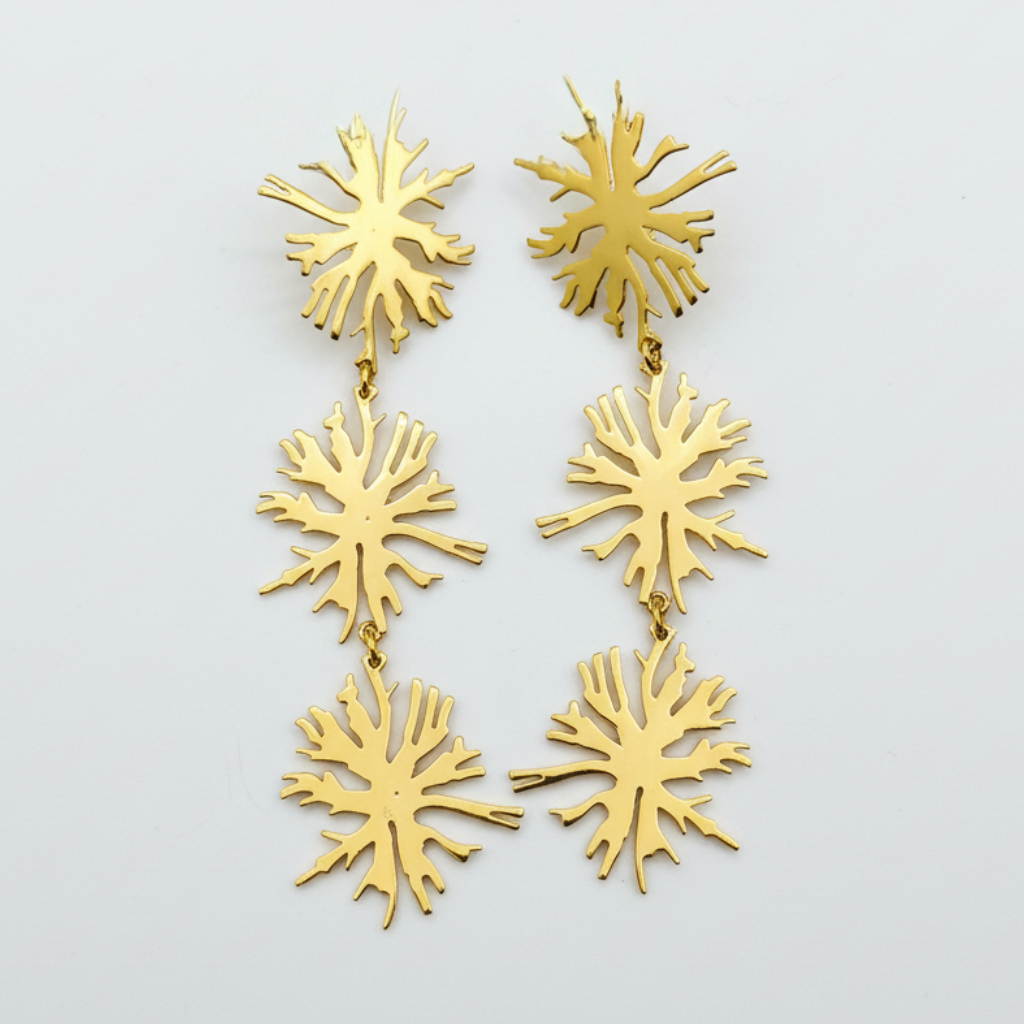 Gold leaf-shaped tri blossom earrings on a light gray background